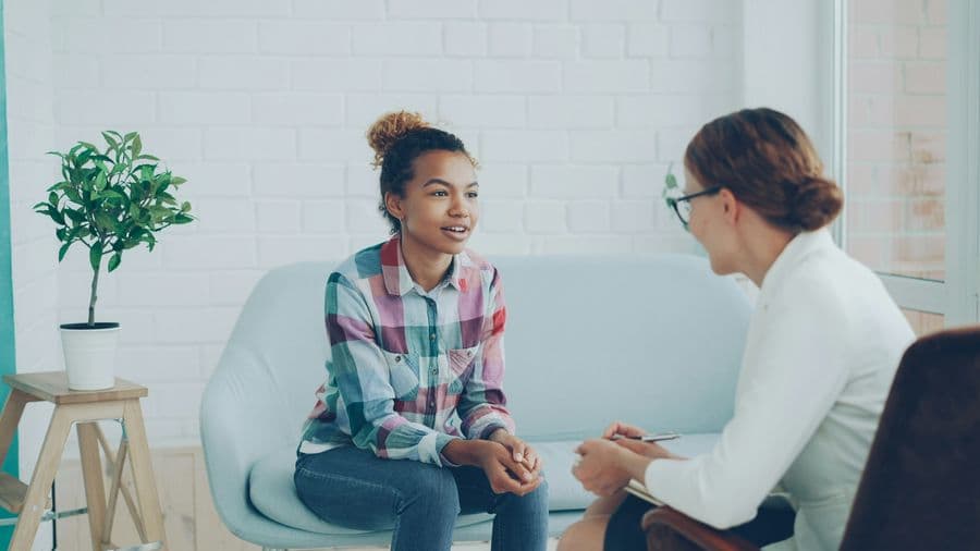 Zwei Frauen im vertrauensvollen Gespräch in einem hellen Praxisraum
